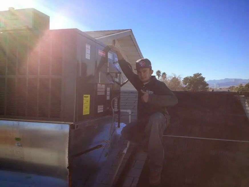 HVAC technician performing Air Duct Repair on a rooftop unit in Holtville